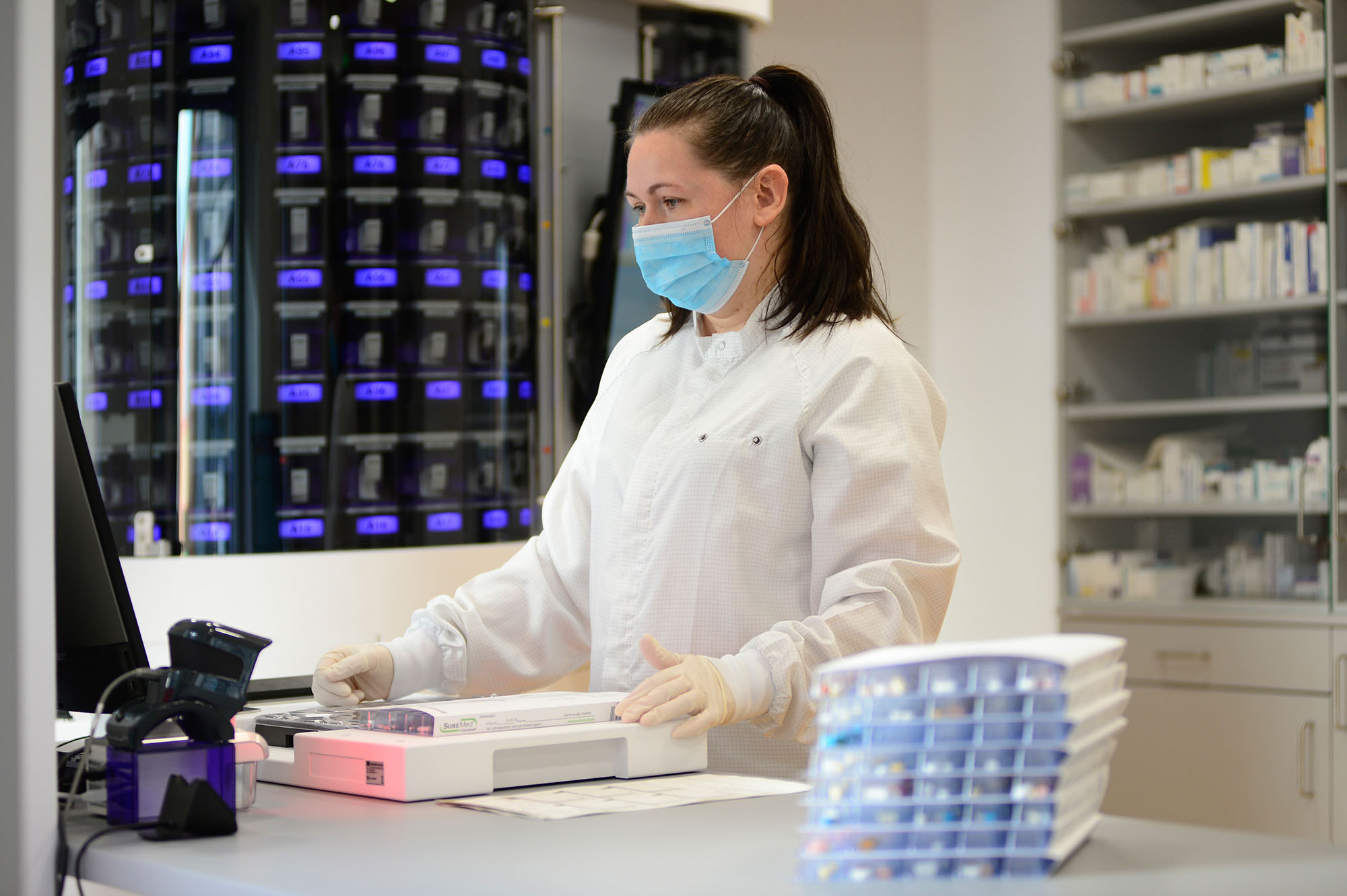 Mitarbeiterin hält Blisterkarte in den Händen