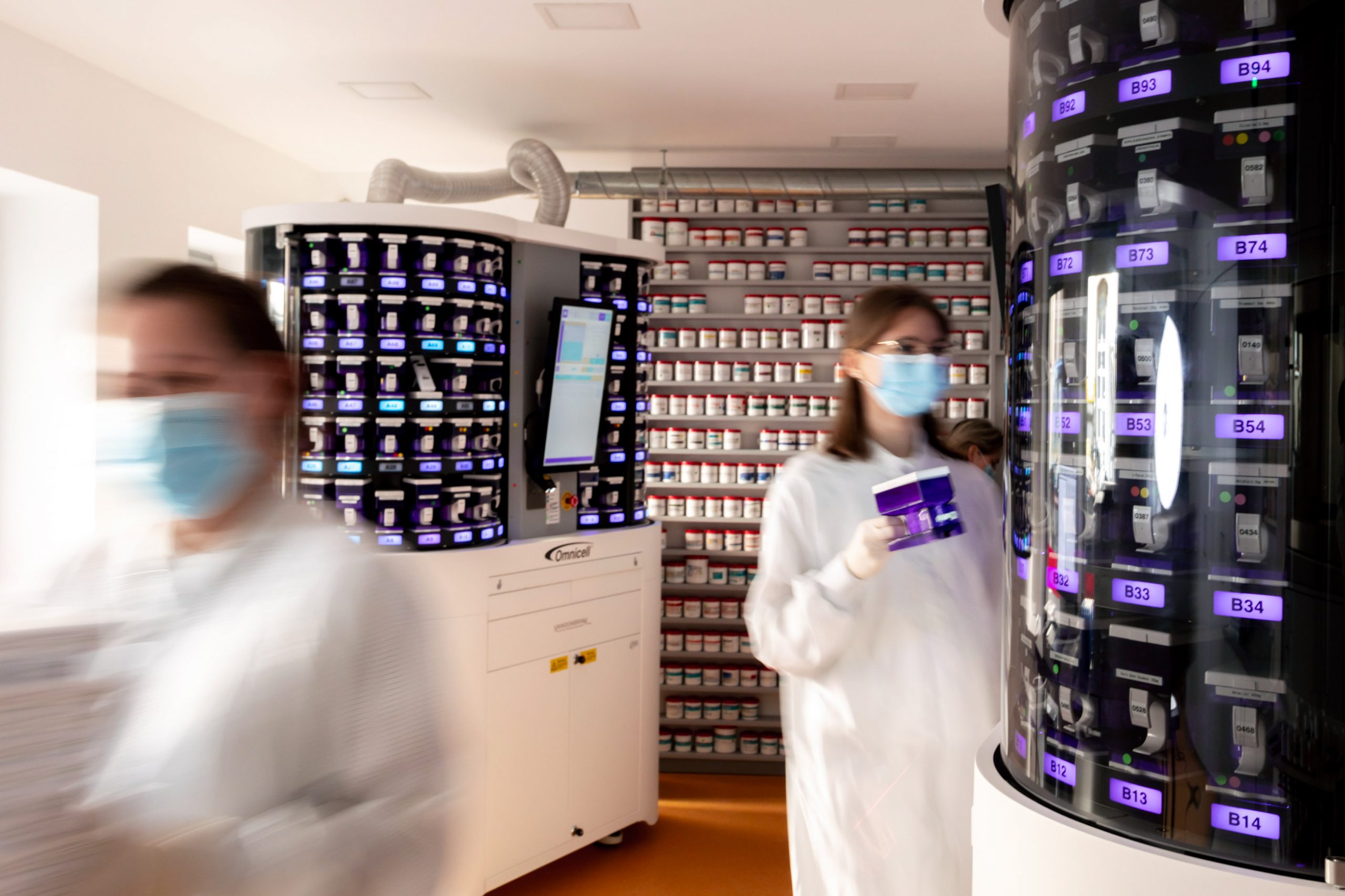 Mitarbeiterinnen im Blisterzentrum neben zwei Blistermaschinen