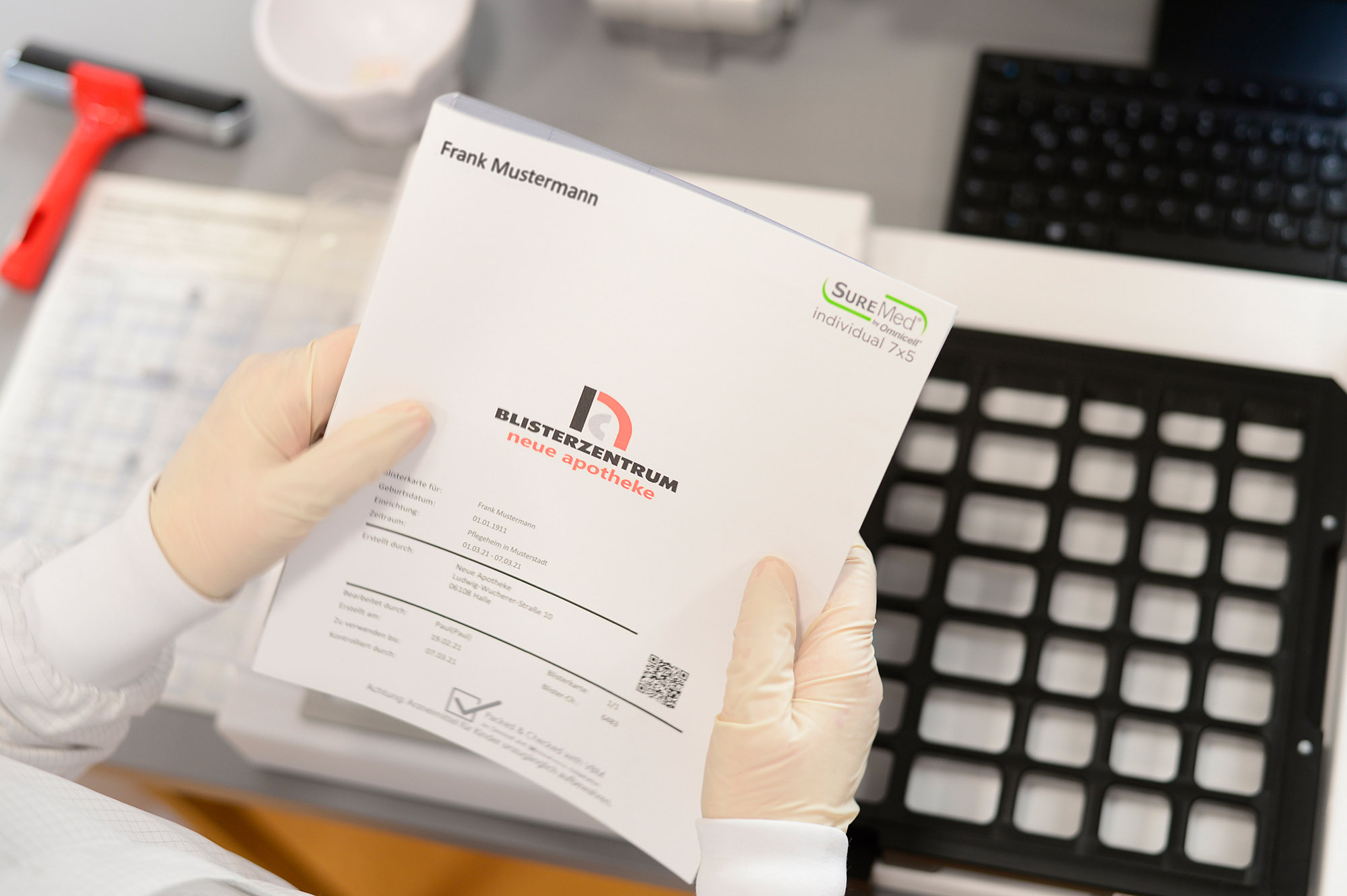 Mitarbeiterin hält Blisterkarte in den Händen